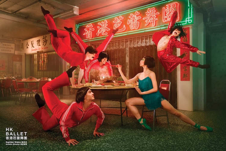Promotional image for HK Ballet: five dancers in red tracksuits perform acrobatic poses around a dining table in a neon-lit restaurant; a woman in a teal dress watches.