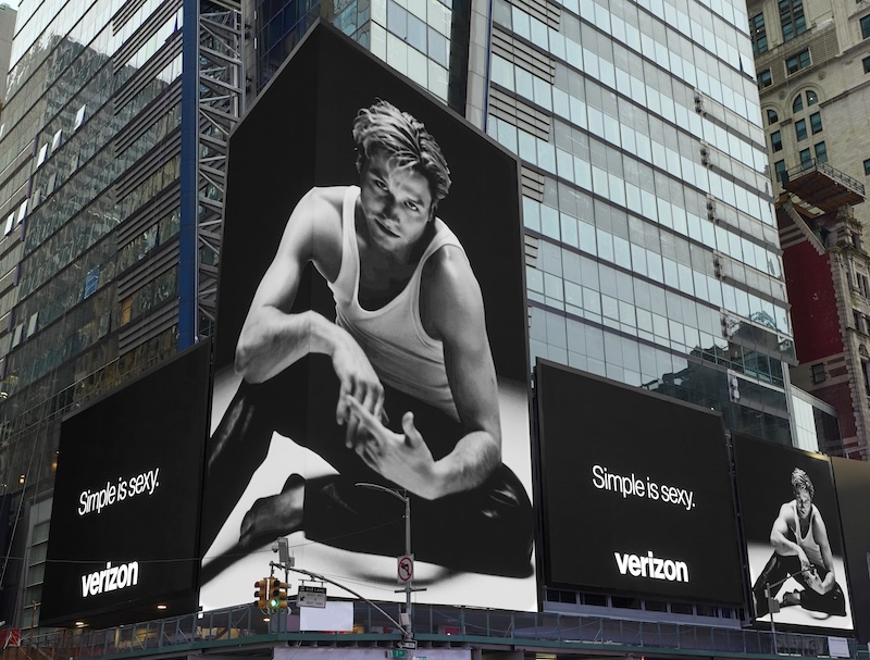 Verizon billboard with a grayscale portrait of a man in a white tank top and the caption 'Simple is sexy.'
