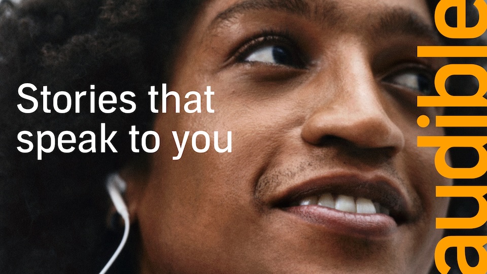 Close-up of a smiling person with earphones, featuring the slogan'Stories that speak to you' and vertical 'Audible' branding on the right.